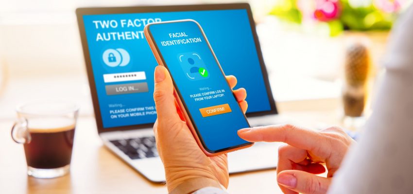 Woman using two factor authentication on laptop computer and mob secure your passwords by using two factor authentication